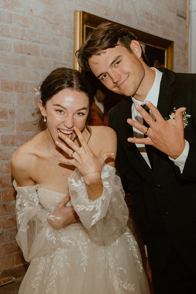 wedding couple holding out there left hands showing off their wedding rings