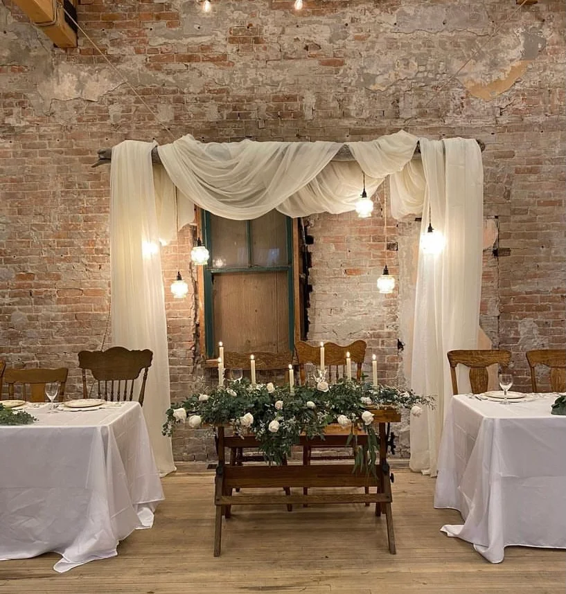 Vintage classic sweetheart table with candlesticks, antique chairs, and luminous lantern backdrop