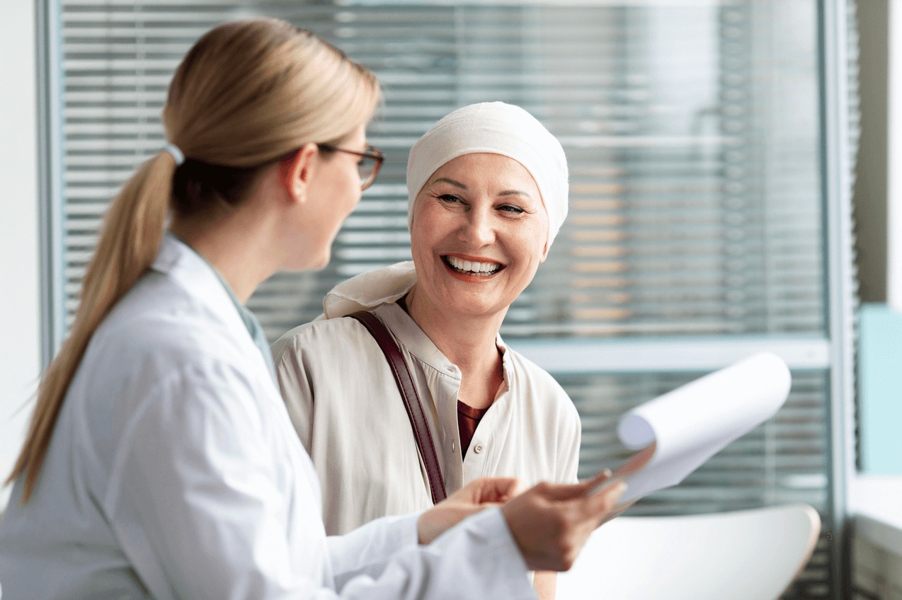 Smiling breast cancer survivor consulting with her doctor about HBOT for failed flaps after breast reconstruction surgery.