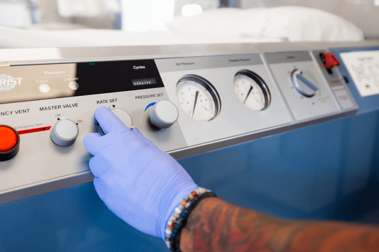A certified hyperbaric oxygen technician adjusts the settings on a hyperbaric oxygen chamber for patients in Sandy Springs
