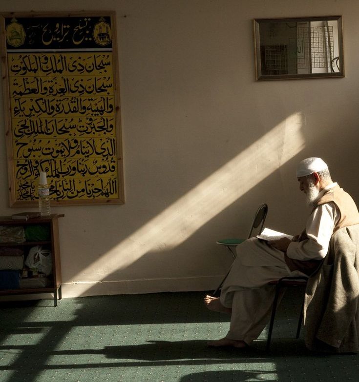 Elderly man reading inside mosque