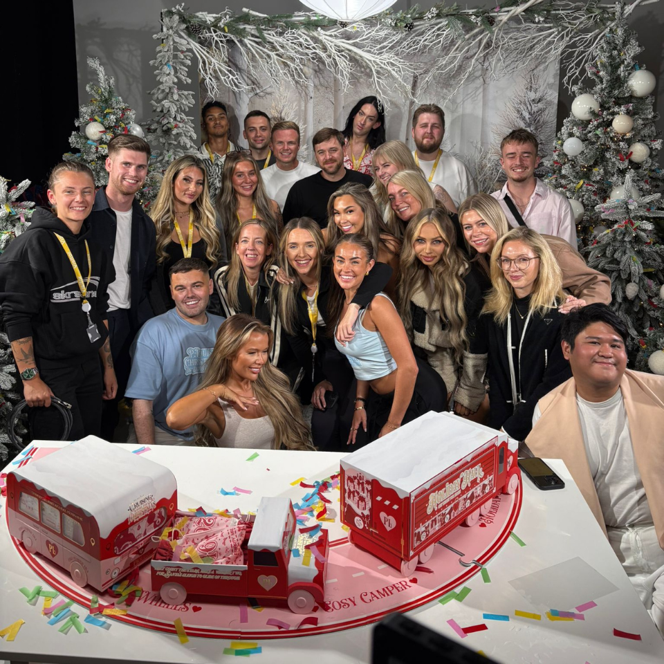 A group of people posing for a picture in front of a Christmas tree.