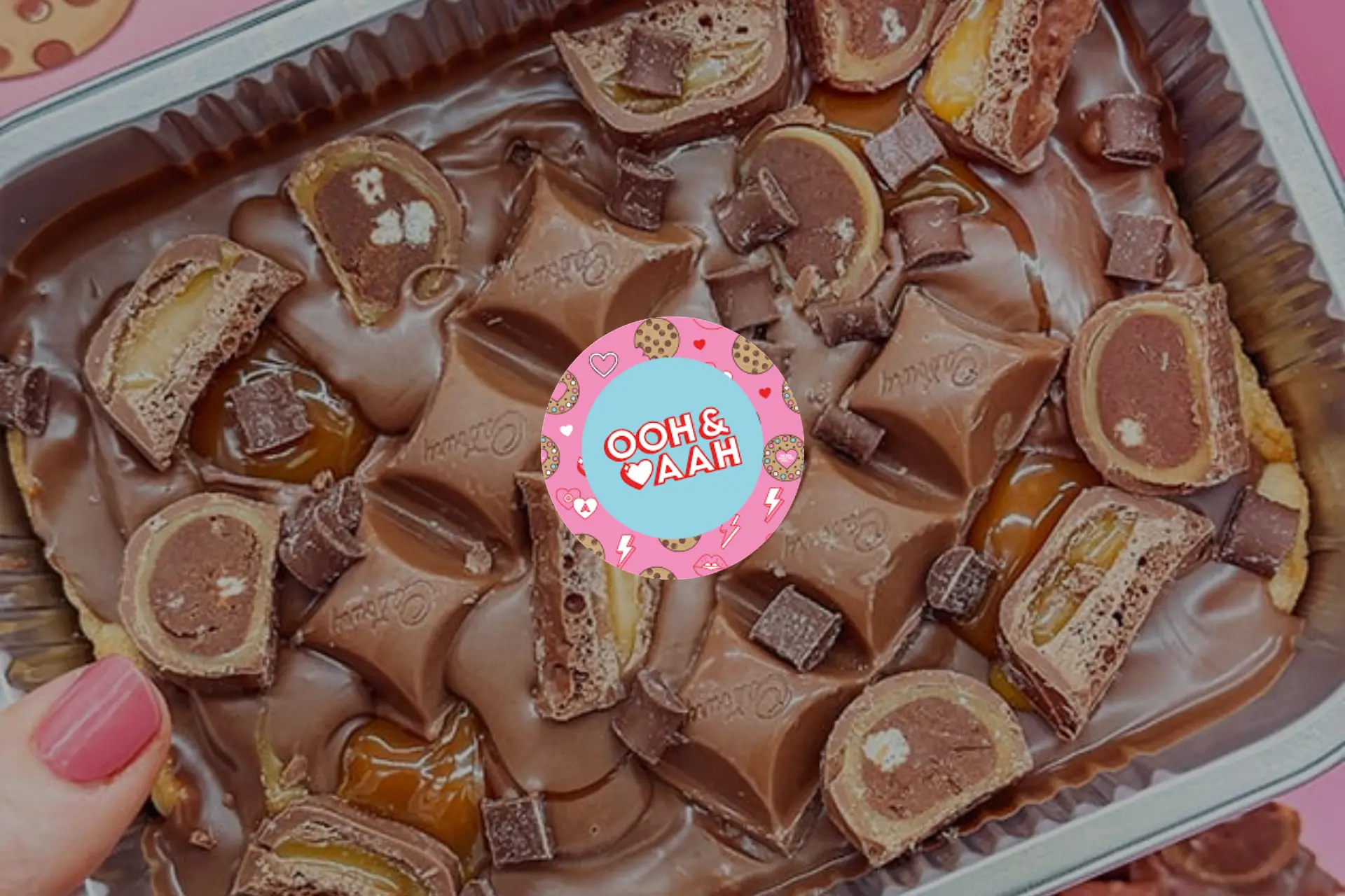 A close up of a chocolate dessert with a pink heart shaped logo.
