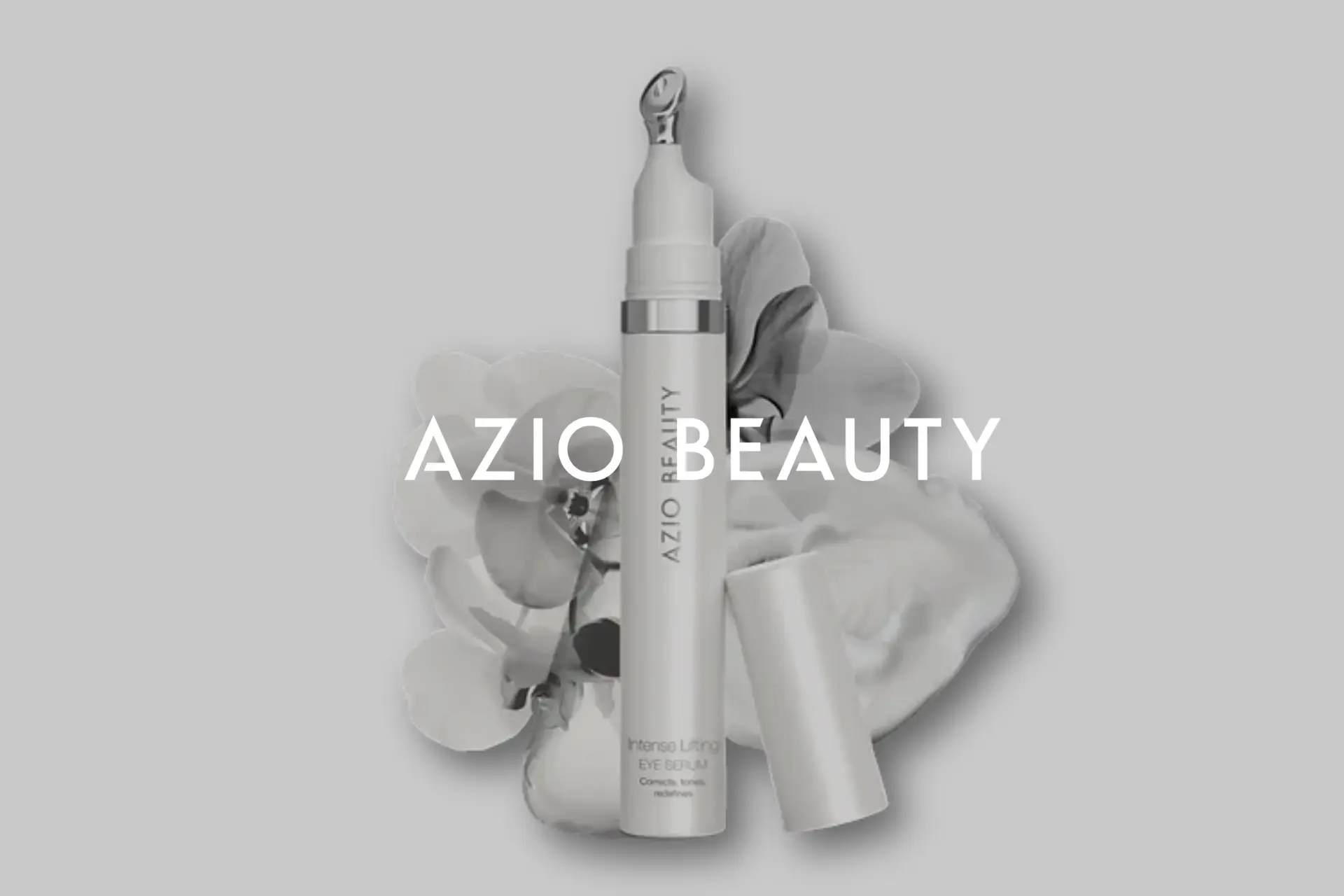 A bottle of AZIOL Beauty sits on a table with a flower.