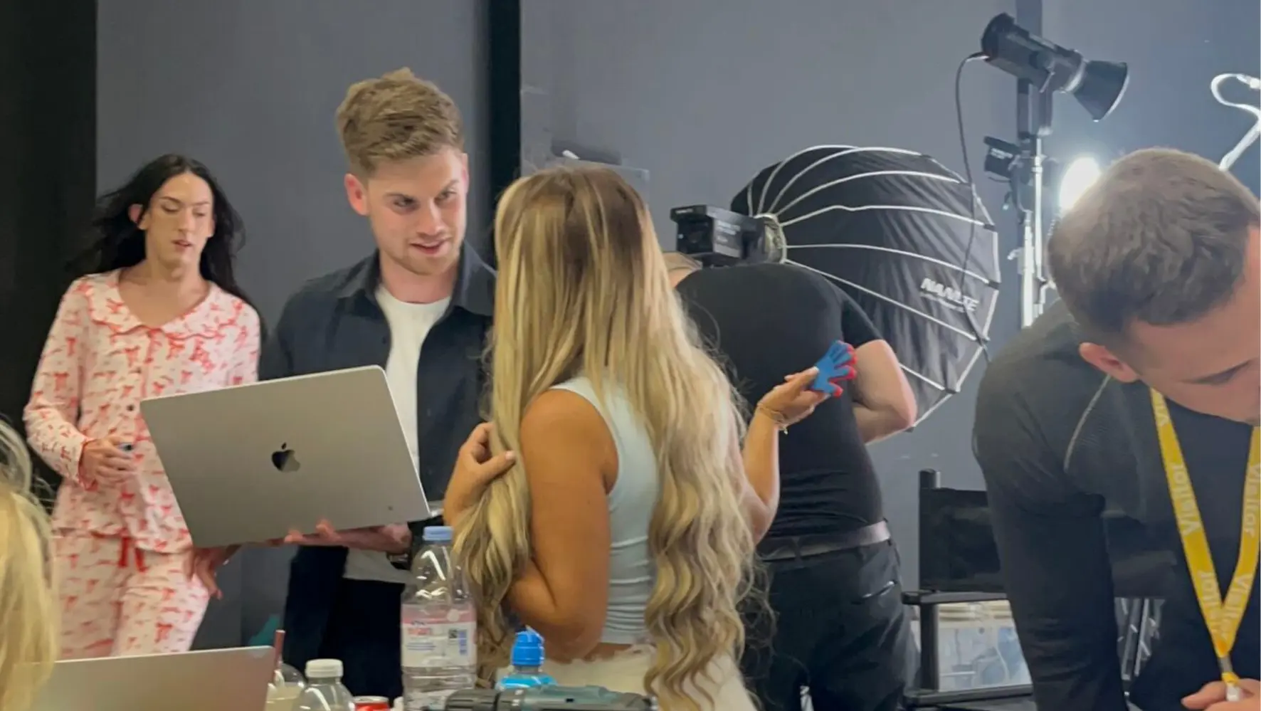 A man holding a laptop and a woman with blonde hair.