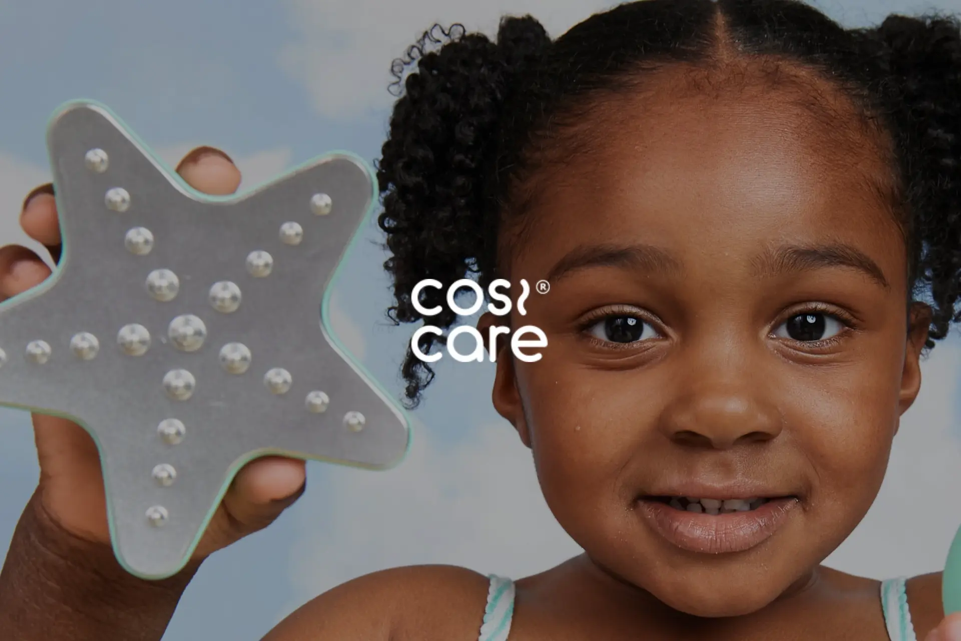A young girl holding a star shaped toy.