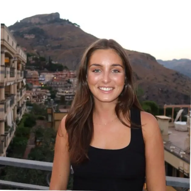 A woman wearing a black tank top and smiling.