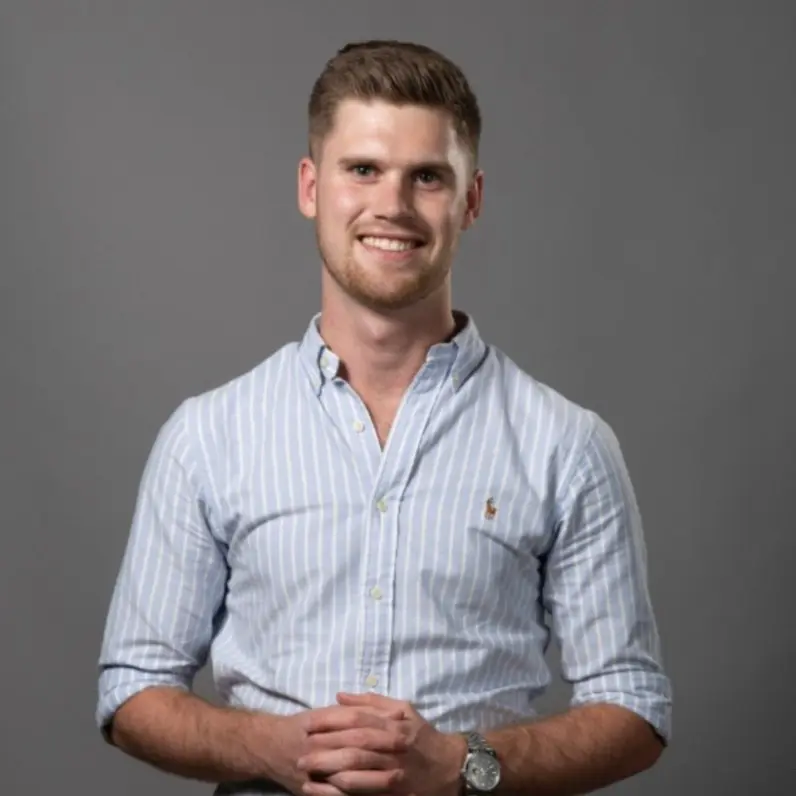 A man wearing a blue striped shirt and a watch.