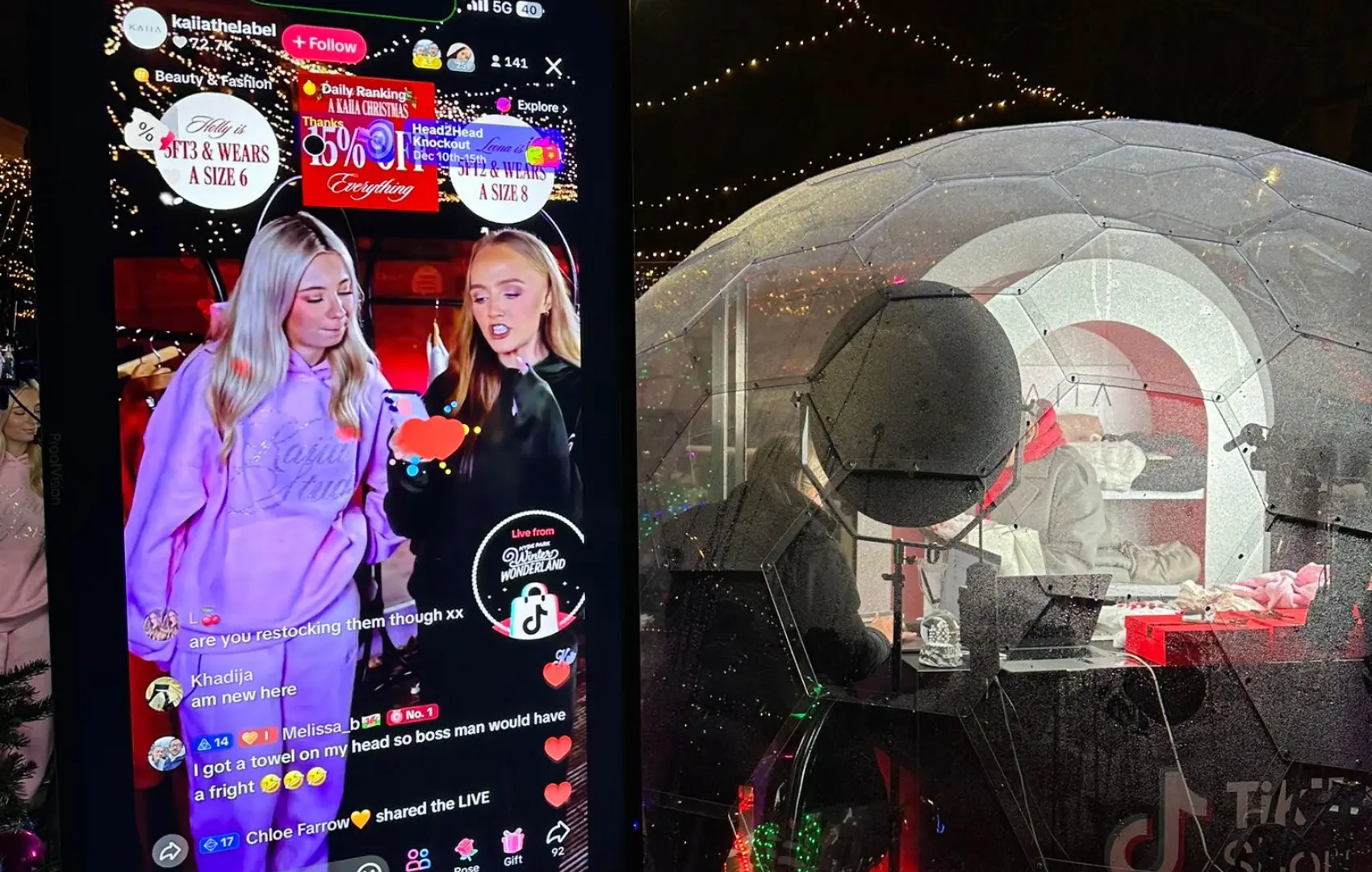 A woman is standing in front of a large screen that shows a picture of a woman.