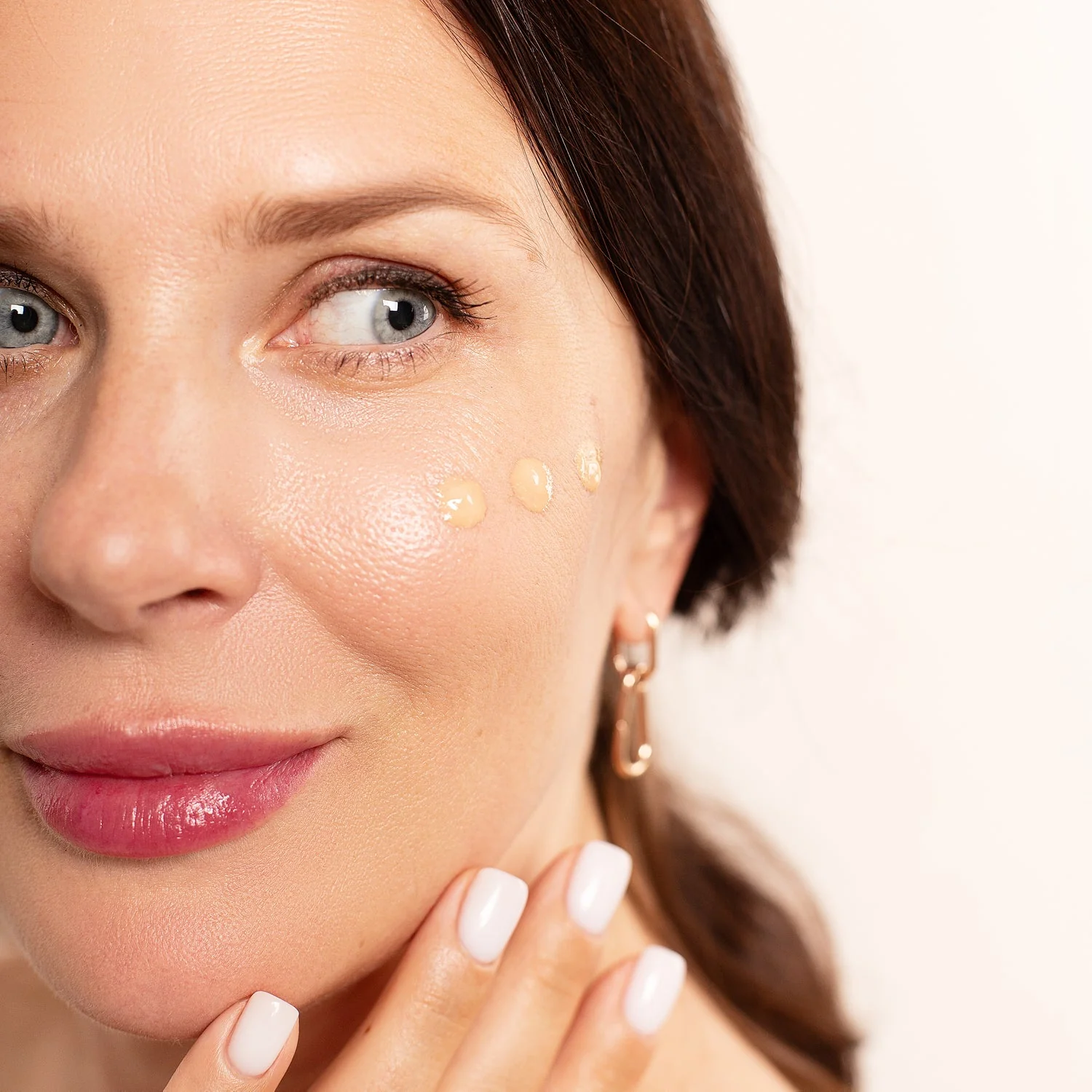 A woman with a white shirt and white nail polish.