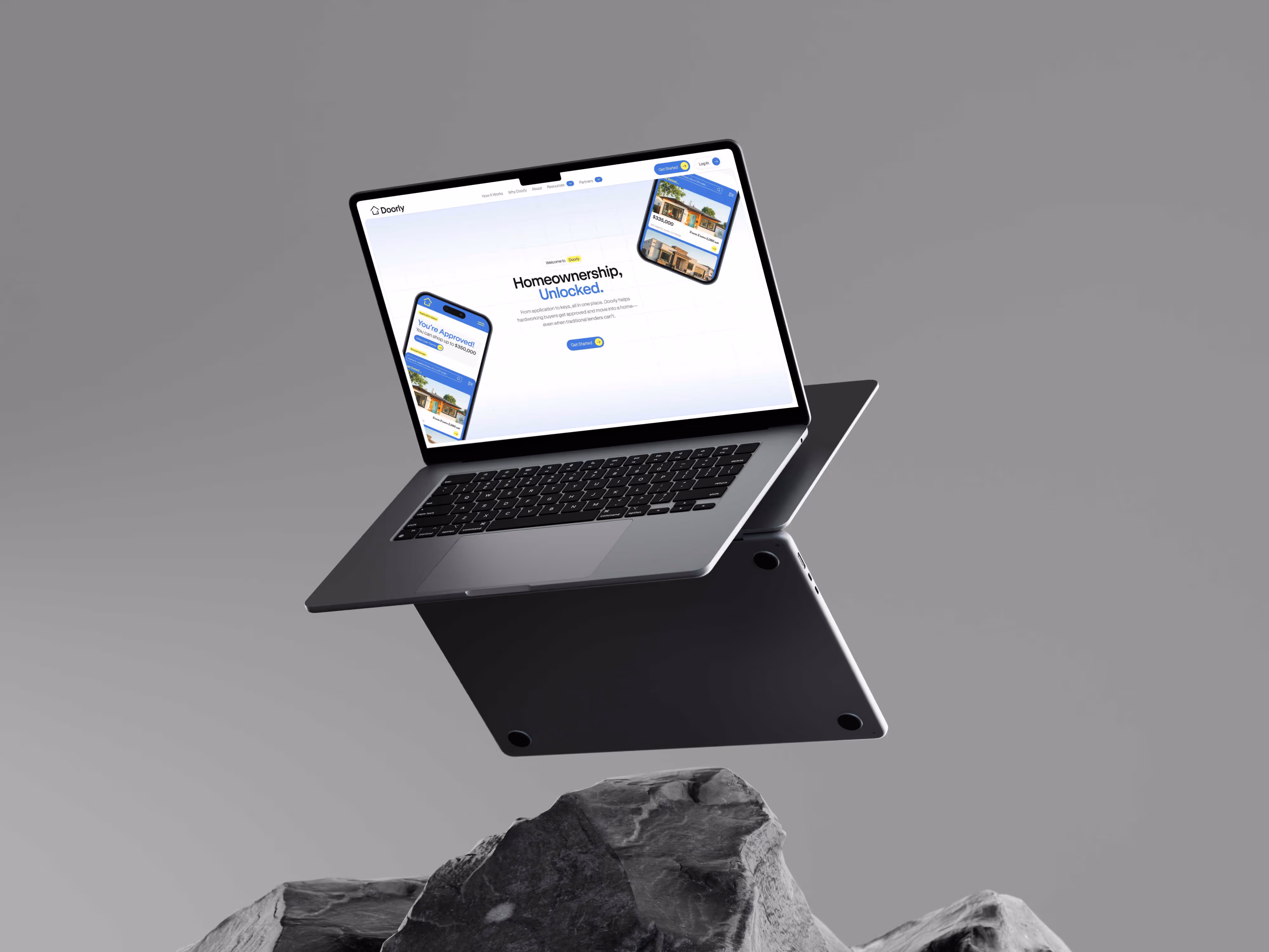 Open MacBook Air 15 laptop floating above gray rocks with a website about homeownership displayed on its screen.