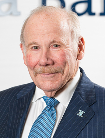 A professional headshot of John Slayton, the Managing Director of First Carolina Wealth. He has a warm smile and is looking directly at the camera.