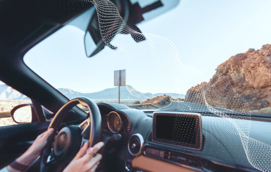 Hands on a steering wheel and the dashboard shown