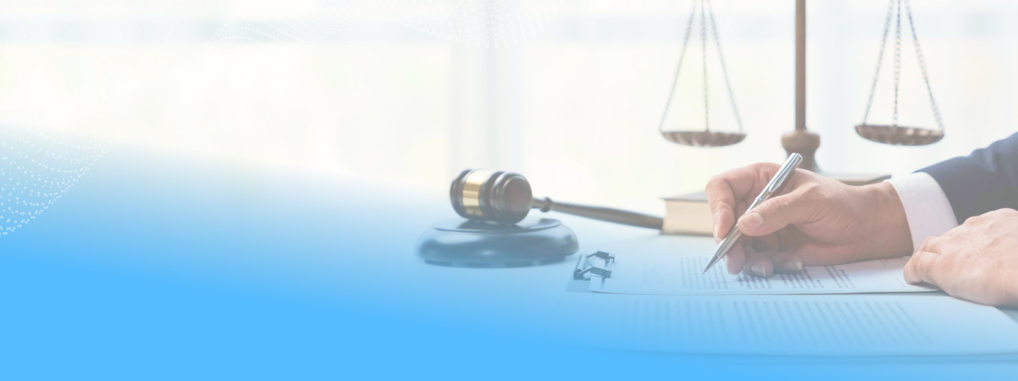 Legal scale and gavel with a male hand writing on a piece of paper