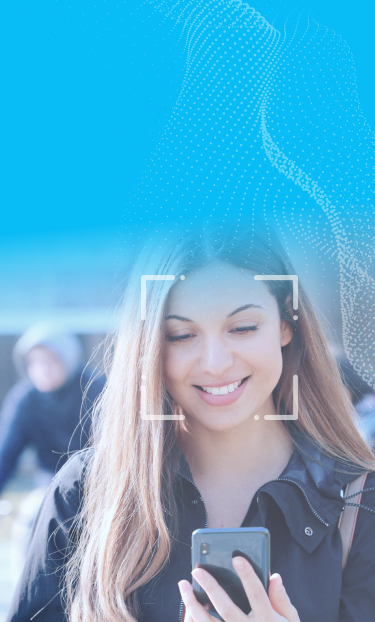 Woman looking down at her mobile phone. There is a light grey square around her face denoting a snapshot of her face for identity.