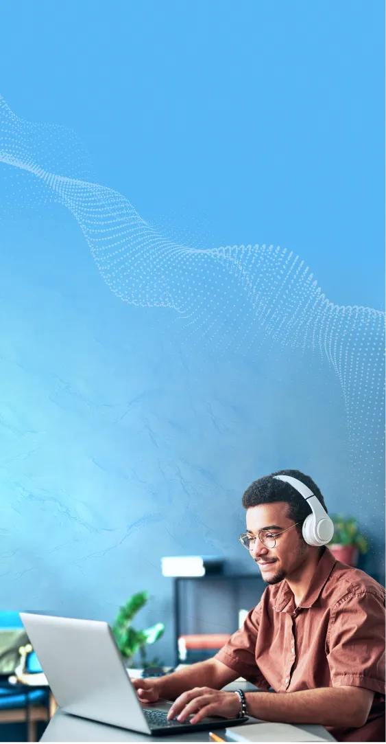 Student male with headphones on and working on a laptop
