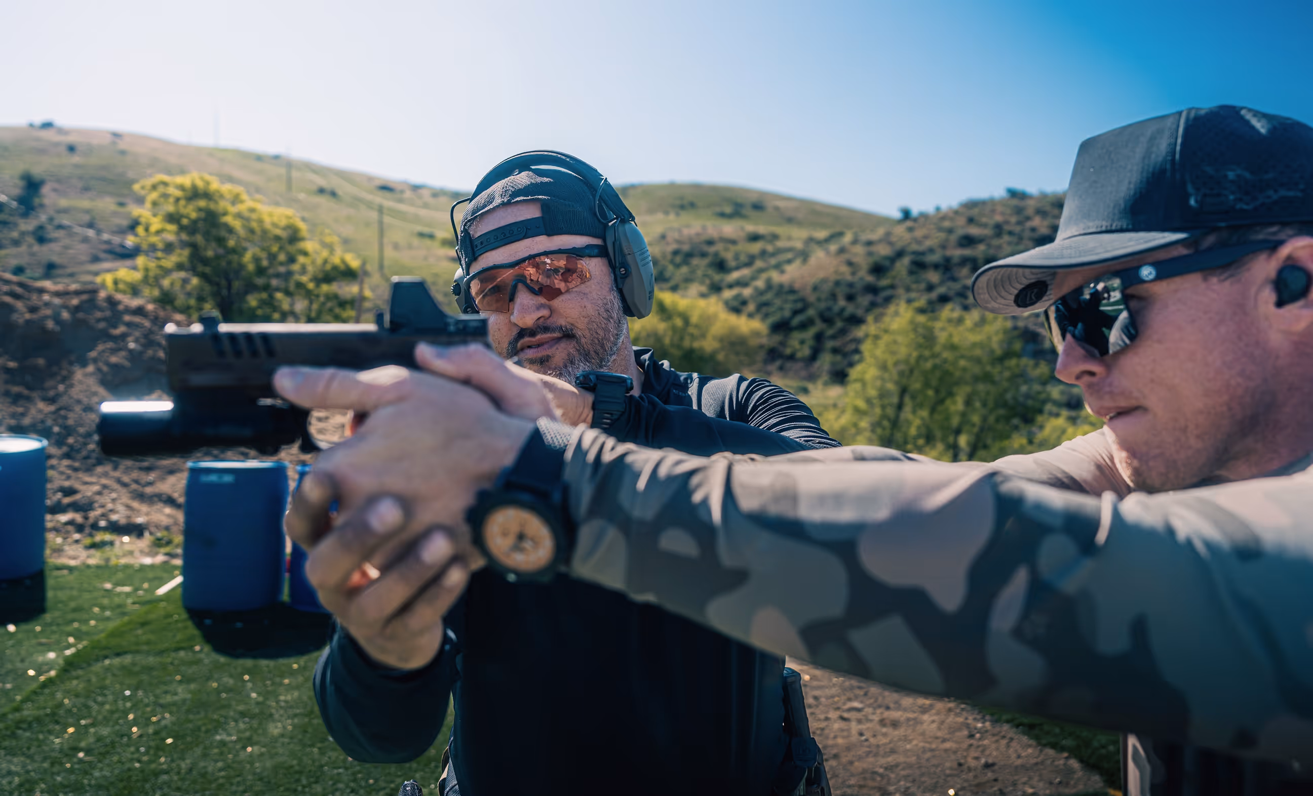 Founder Nate Castillo provides one-on-one firearms coaching in the Boise, Idaho foothills, guiding a shooter through proper pistol grip and stance during private training at Valiance.
