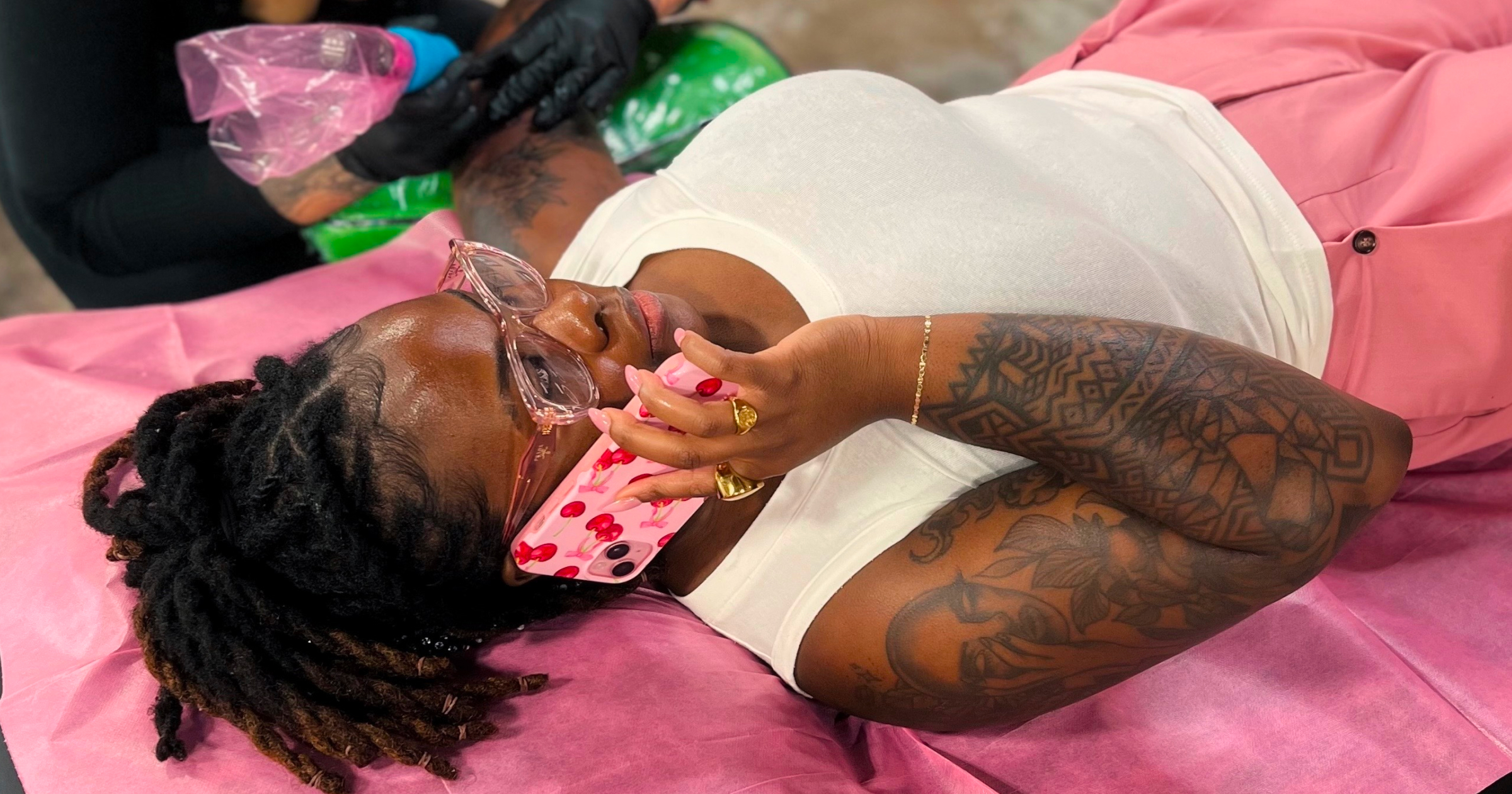 A cute photo of Crystal Douglas sitting in a park in front of a pink backdrop.