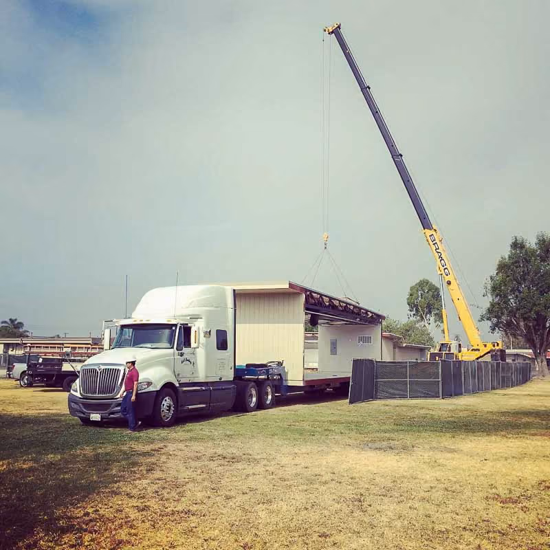 Crane rigging a modular section onto a trailer