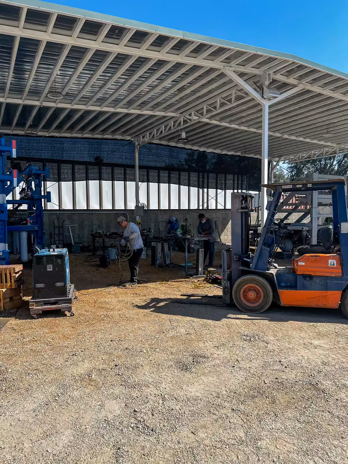Forklift and crew under the steel canopy at the Cid's yard