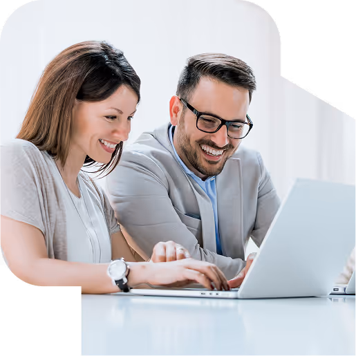 Two smiling business professionals working together on a laptop in a bright office.