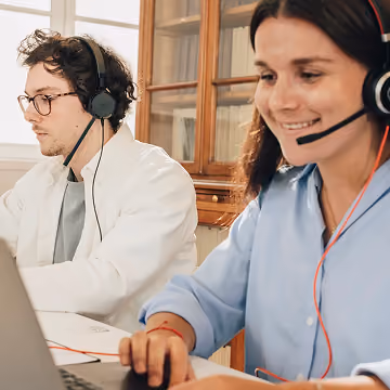 Deux conseillers Zenior équipés d’un casque micro devant leurs ordinateurs