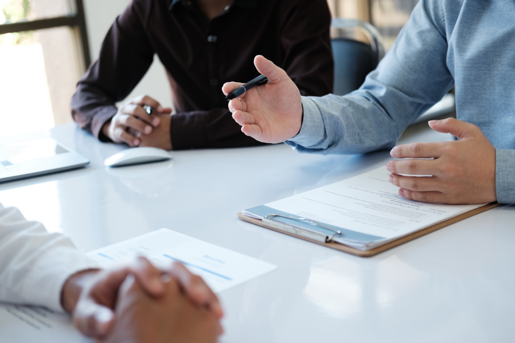 A hiring manager reviewing a candidate's CV across a meeting table