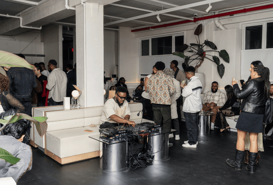 People socializing in a bright modern loft lounge with plants and white columns