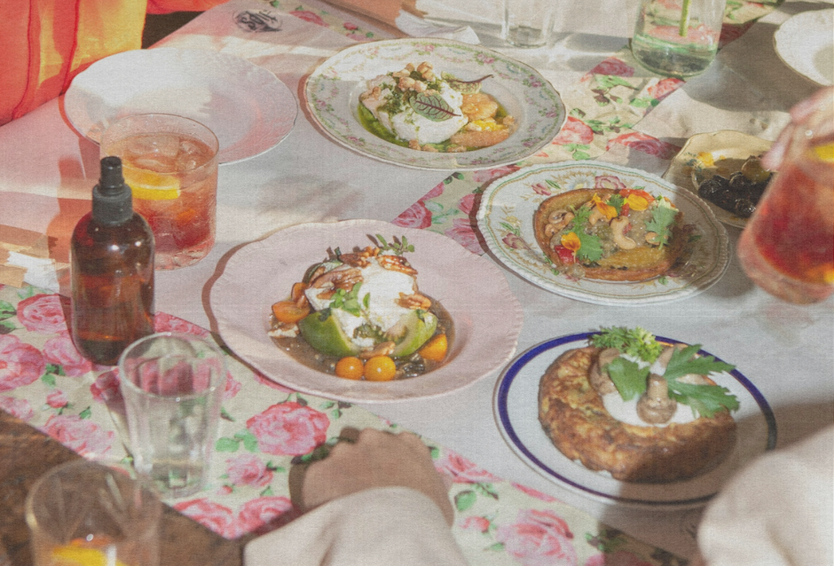 Brunch table spread with plated dishes, drinks and a floral patterned cloth