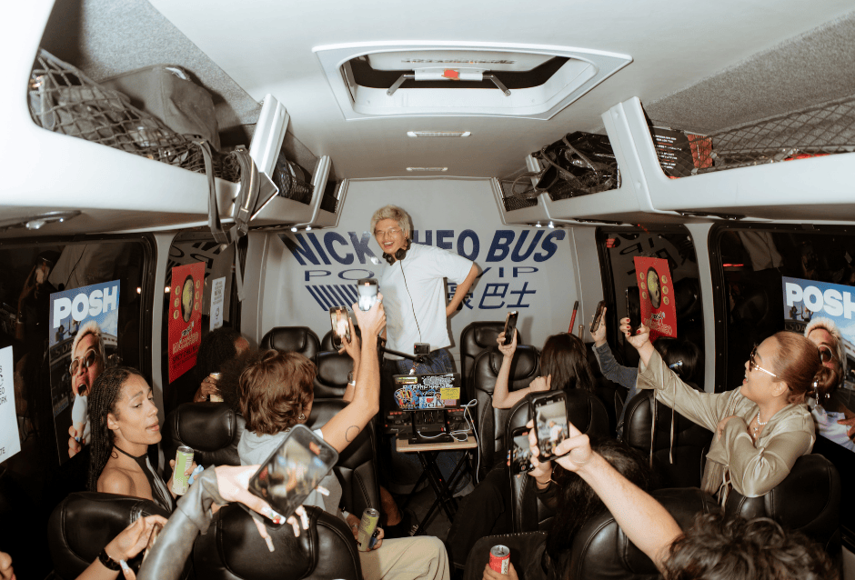 Excited group celebrating with raised arms inside a party bus