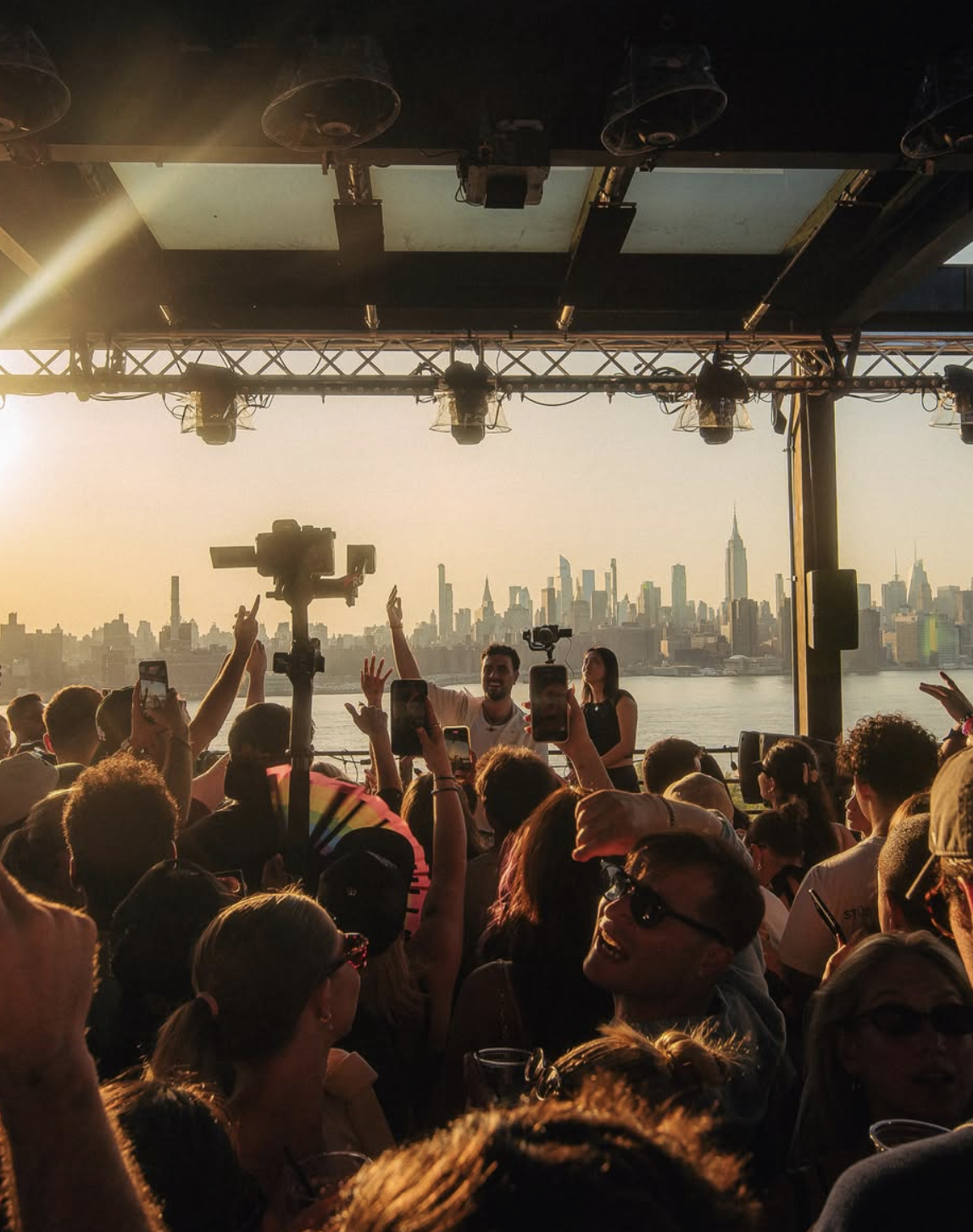 Golden hour crowd at Azure Day Party with the Manhattan skyline across the East River
