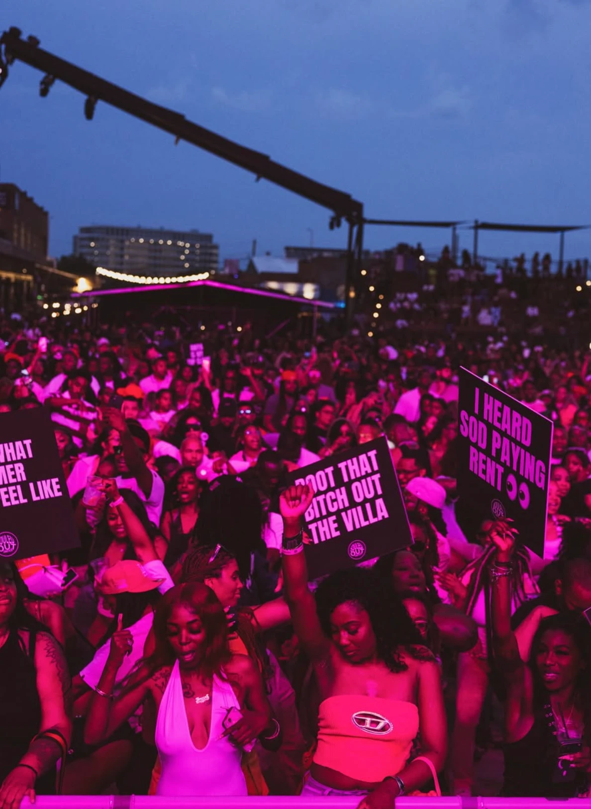 Crowd at a Souled Out Dates show under pink lights, holding SOD signboards