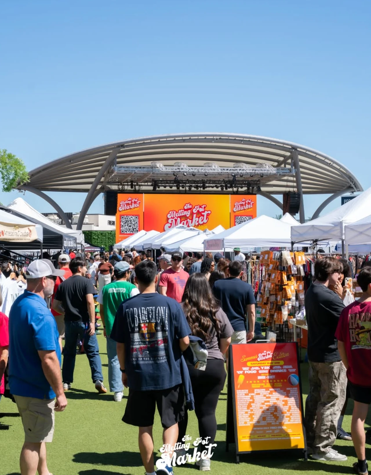 The Melting Pot Market on the lawn at Grandscape, with the branded amphitheater stage behind the vendor tents