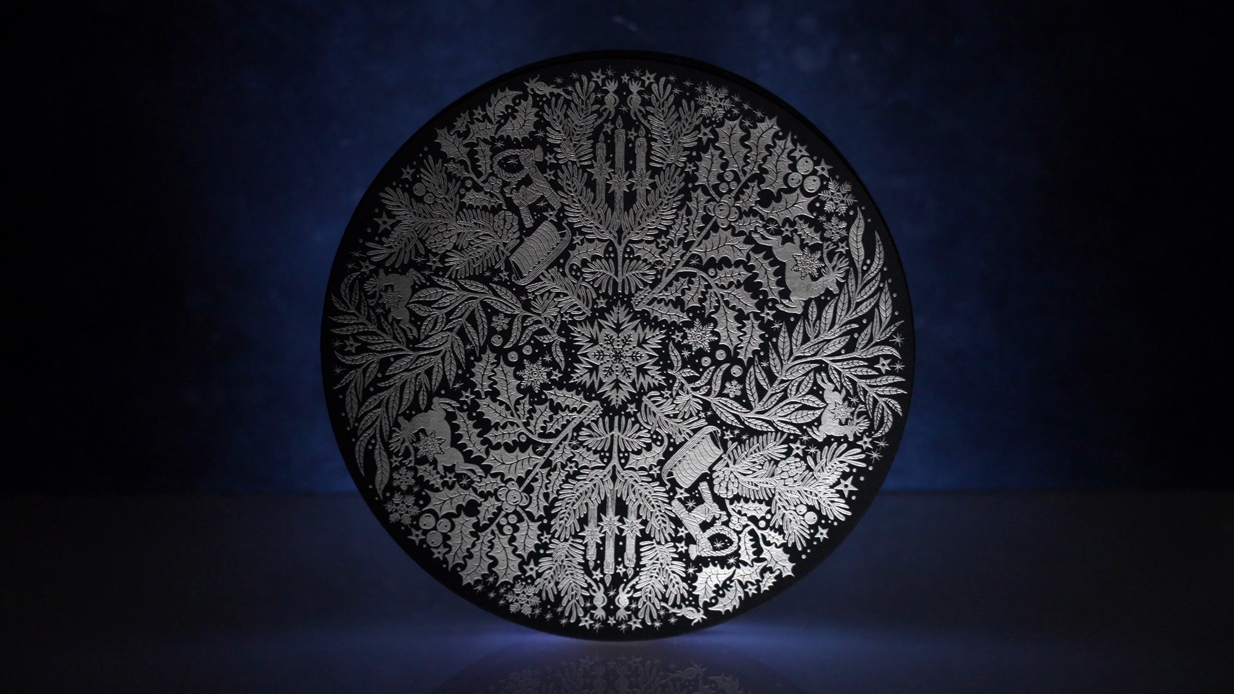 The illustrated lid of the Dandelion Chocolate Advent Calendar emerging from darkness