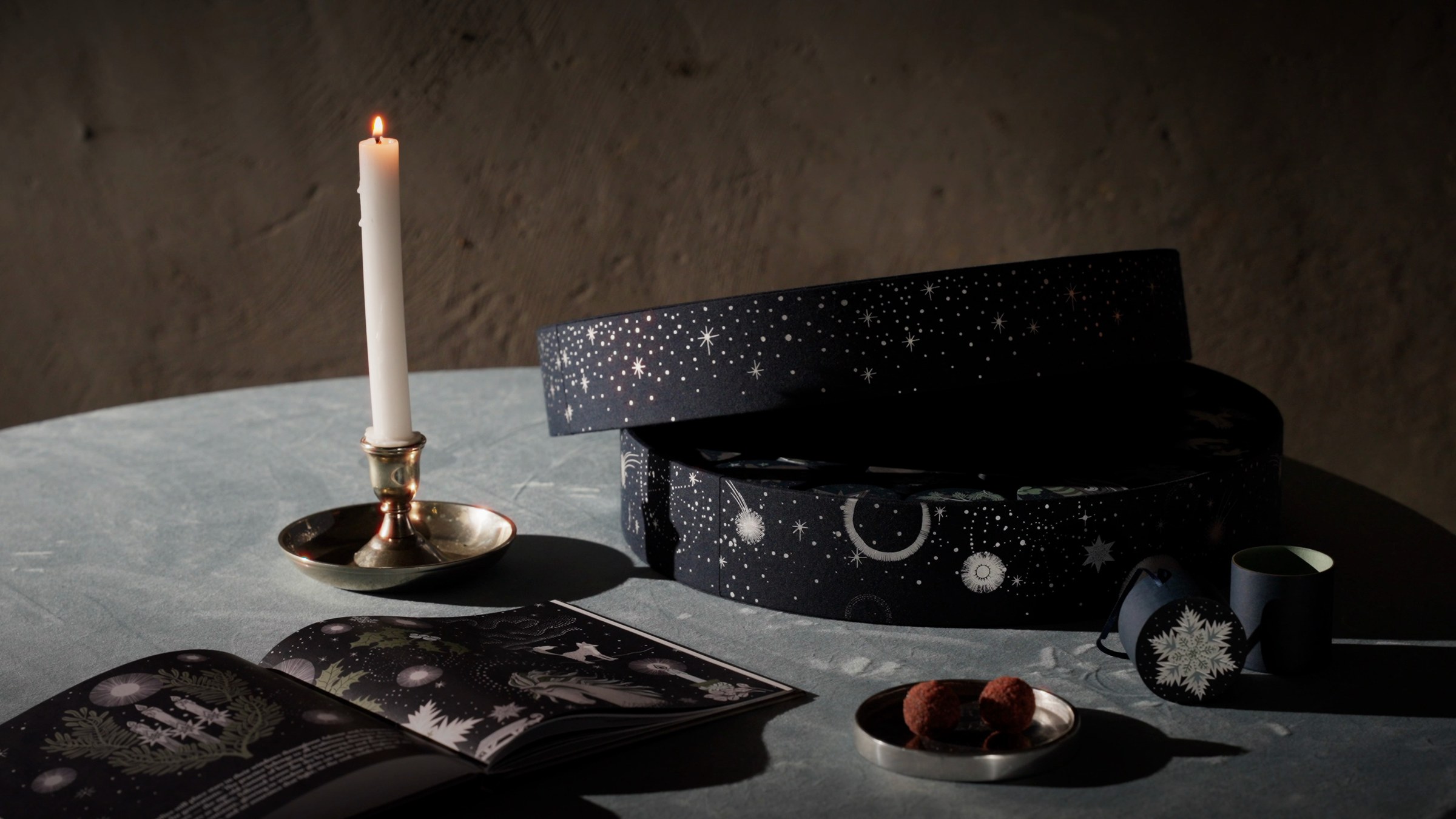 The Advent Calendar and storybook cards on a table by candlelight
