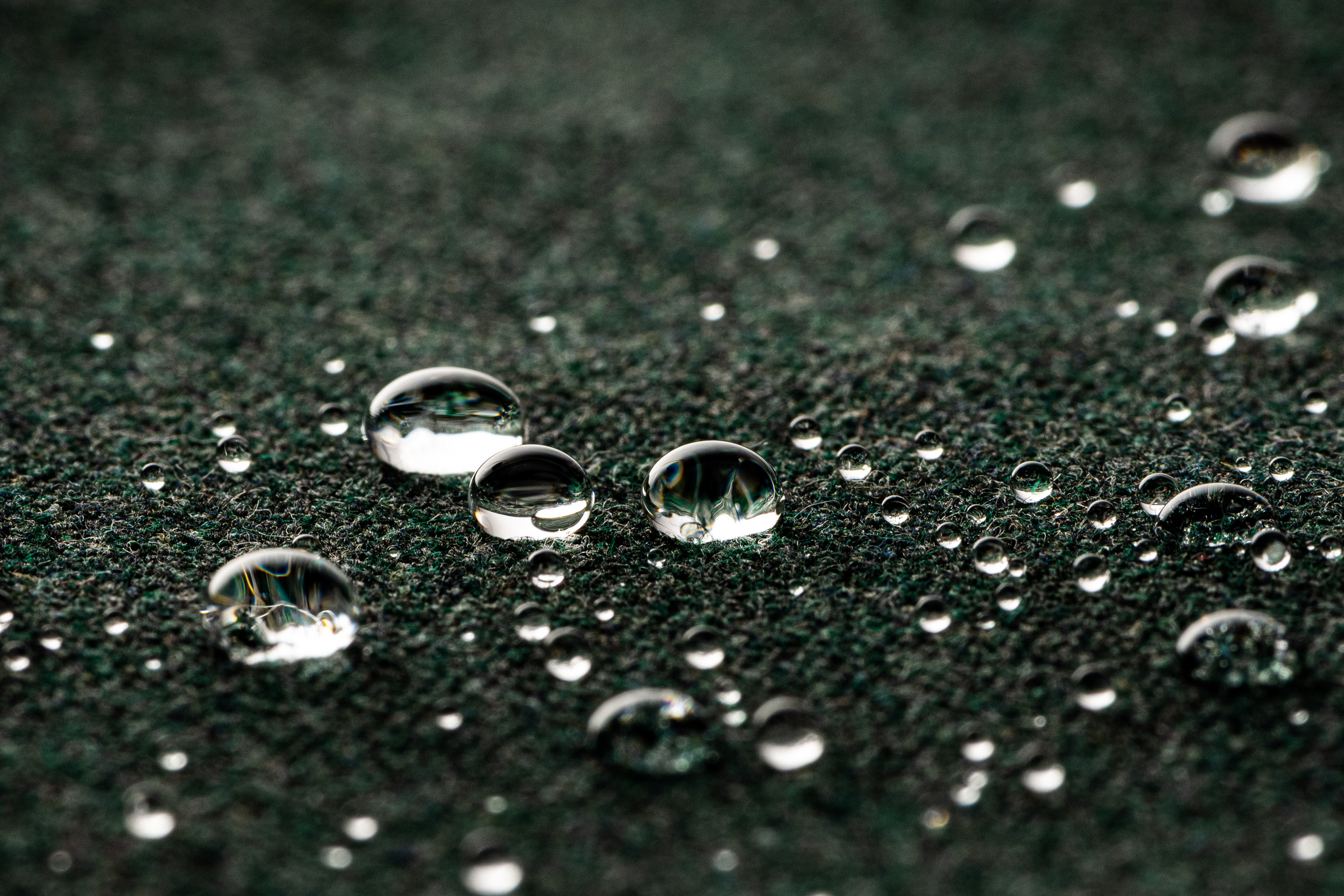 Close-up of water droplets beading on performance outdoor fabric, highlighting Sunbrella’s water repellency