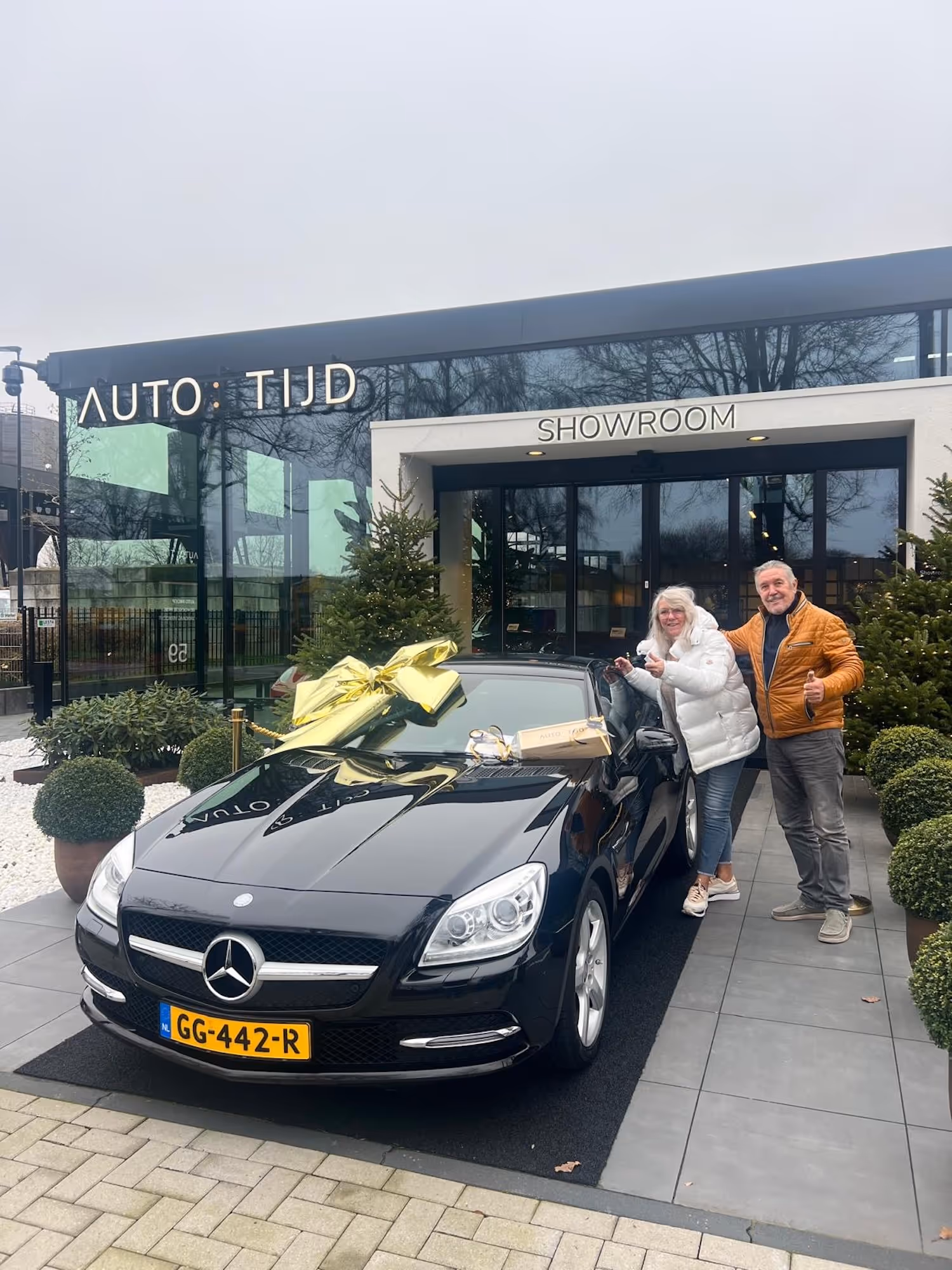 Autotijd-klant met auto voor bedrijsgebouw.