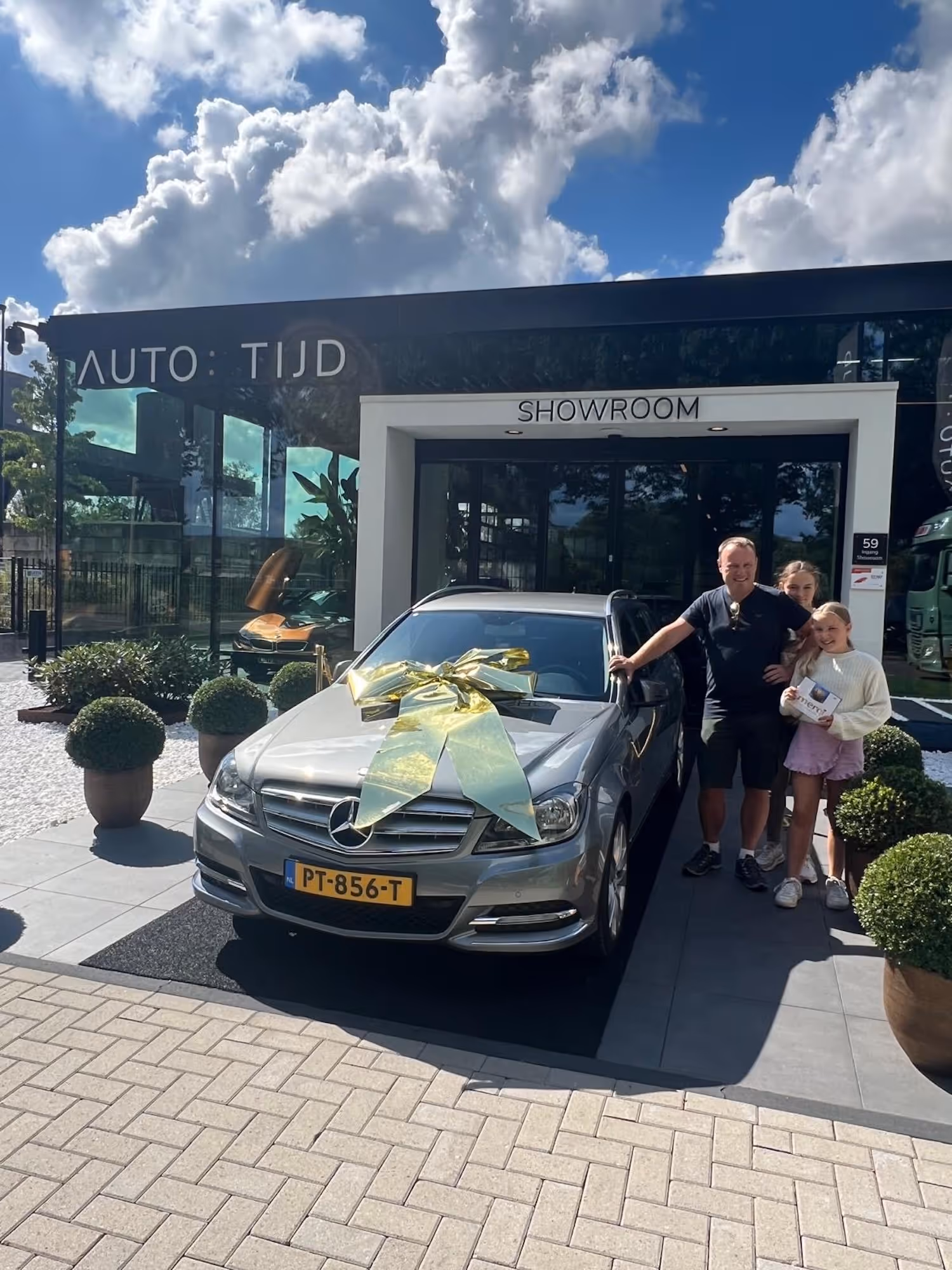 Autotijd-klant met auto voor bedrijsgebouw.