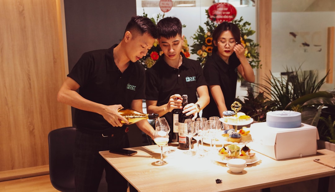 restaurant staff teamwork man in black polo shirt sitting beside woman in black shirt