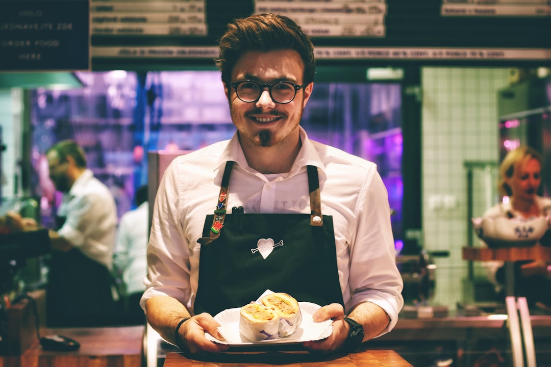 man holding fish dish on plate in a restaurant