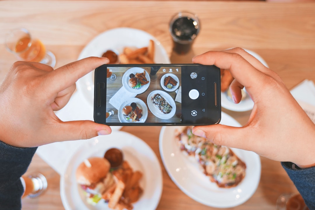person taking picture of the foods in a restaurant for social media marketing