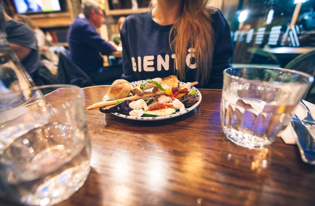 Restaurant food photography showing a beautifully set table with clear drinking glass and white plate