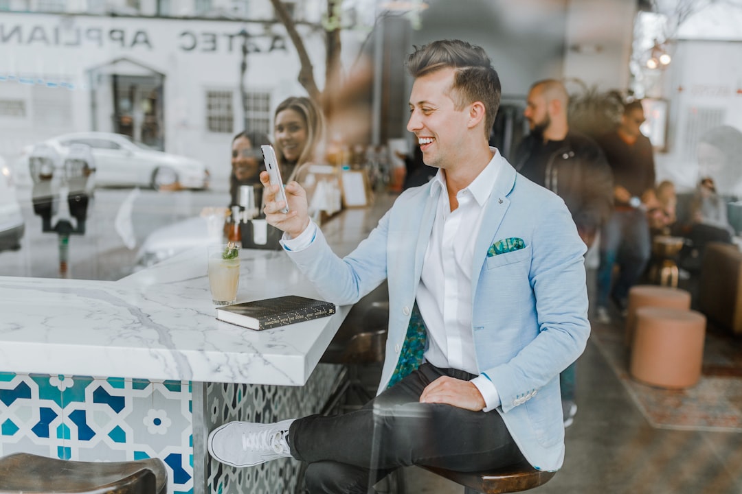 Smiling man holding smartphone representing restaurant viral marketing campaigns