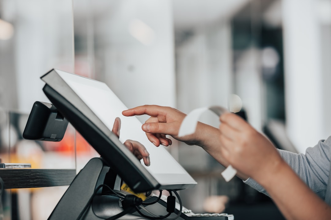 a person is using a POS machine in a store for restaurant management