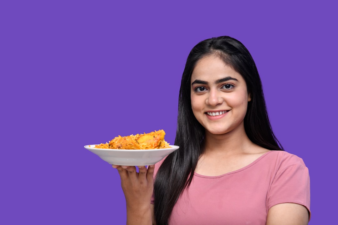 A woman holding a plate of food, highlighting viral food promotion and customer sharing