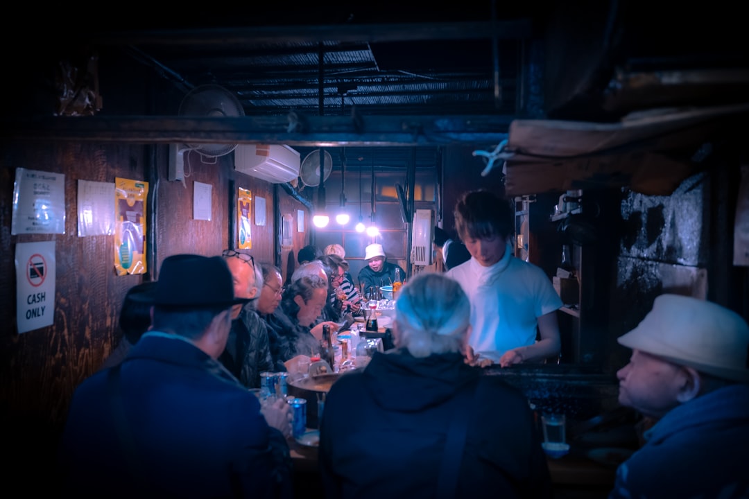 Server following up with guests at a busy restaurant counter to confirm satisfaction.