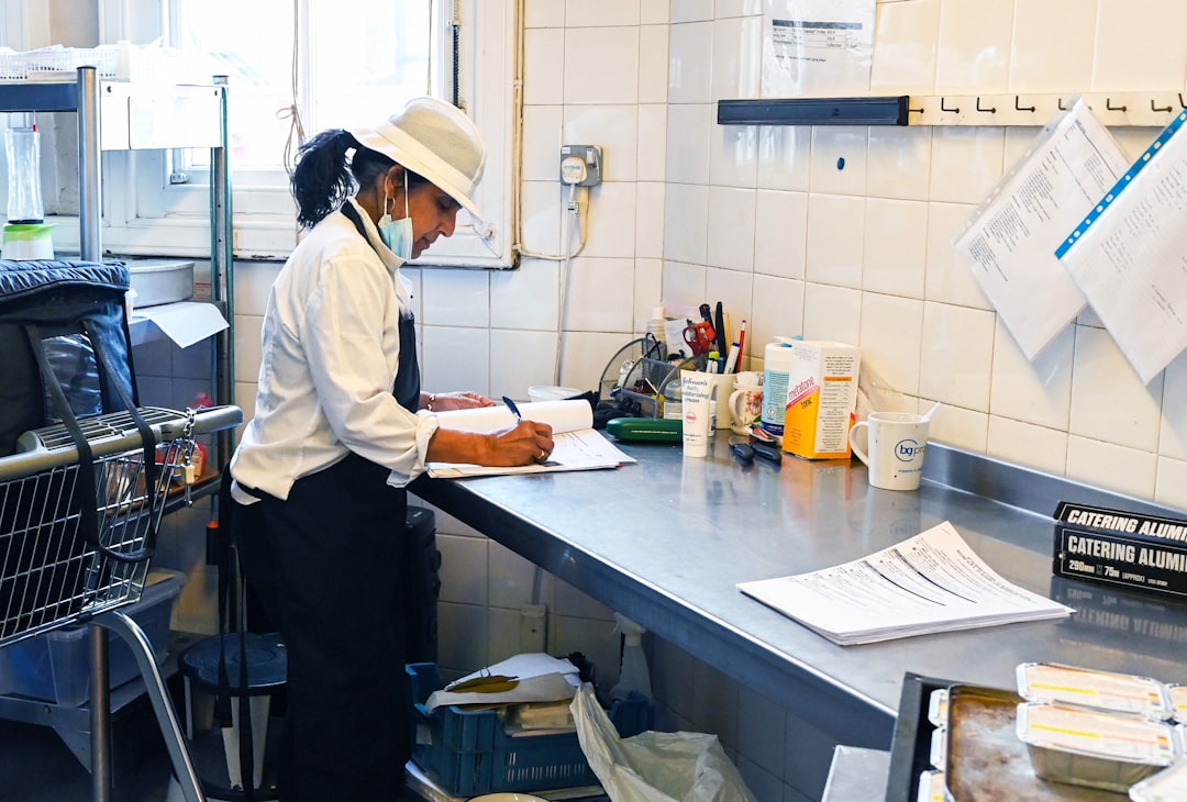 Kitchen staff member writing inventory notes in a commercial kitchen.