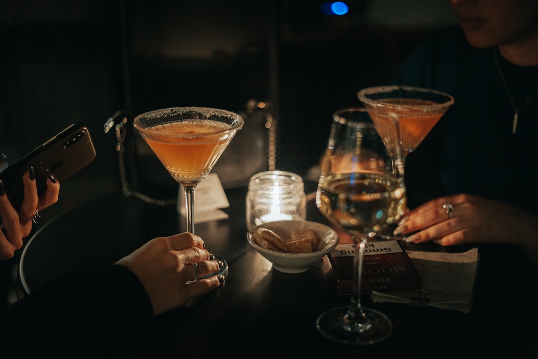 Friends clinking cocktails at a bar during happy hour