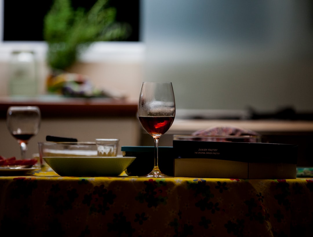 Red wine glass on table set for chef’s tasting dinner and wine pairing
