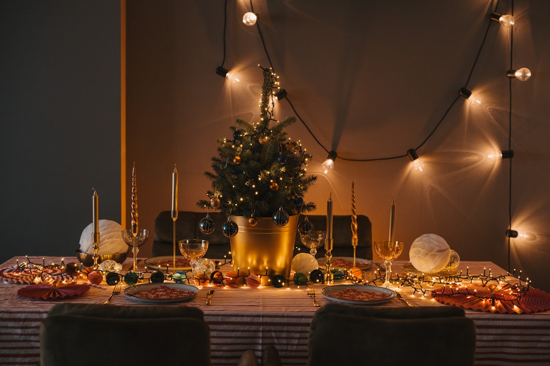 Cozy holiday dining table with candles and a mini Christmas tree.